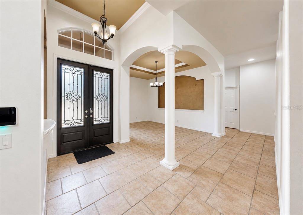 An entryway features a double front door, tile flooring, arched openings, and decorative columns — 6105 AUDUBON MANOR BOULEVARD, LITHIA, FL