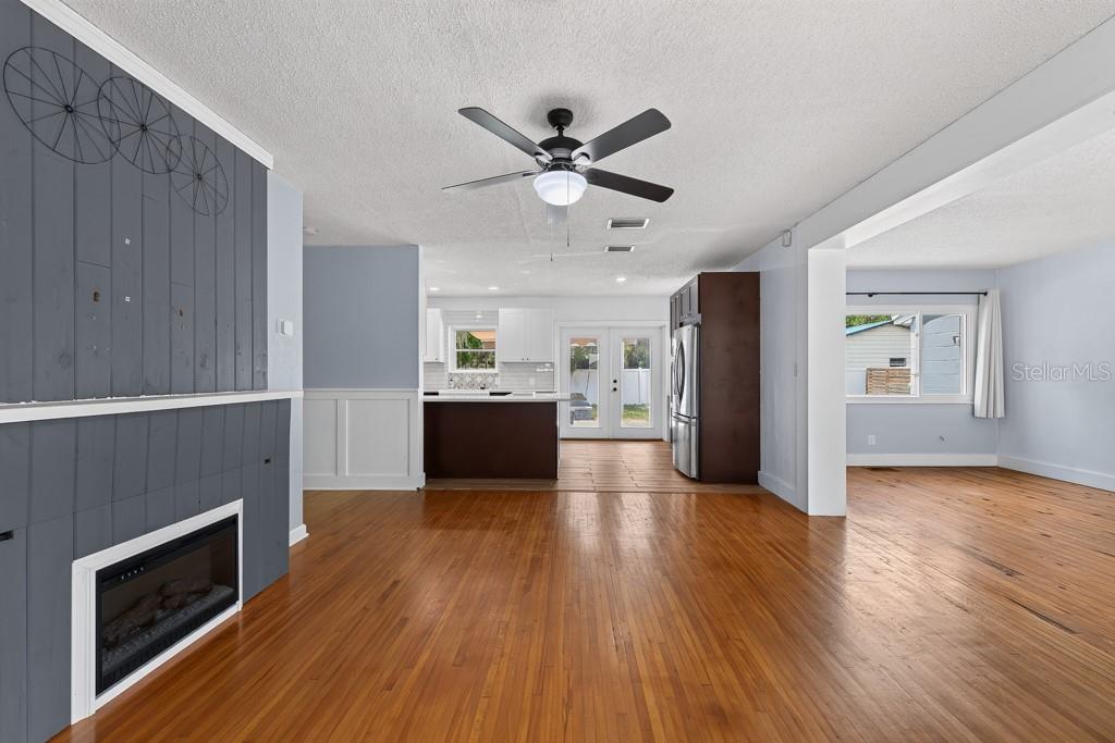 A living room with hardwood floors, a gray fireplace feature wall, and an open kitchen — 215 S ELM ROAD, LAKELAND, FL