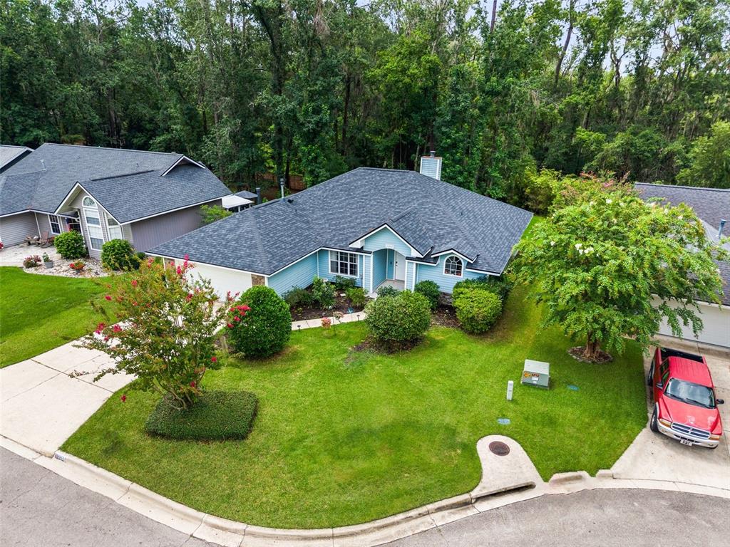An aerial view of a light blue single-story house with a dark shingled roof — 10001 NW 12TH LANE, GAINESVILLE, FL
