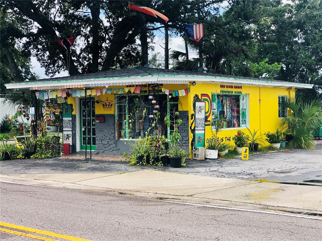 A bright yellow, single-story commercial building with a flat roof and decorative flags — 1726 N FORT HARRISON AVENUE, CLEARWATER, FL