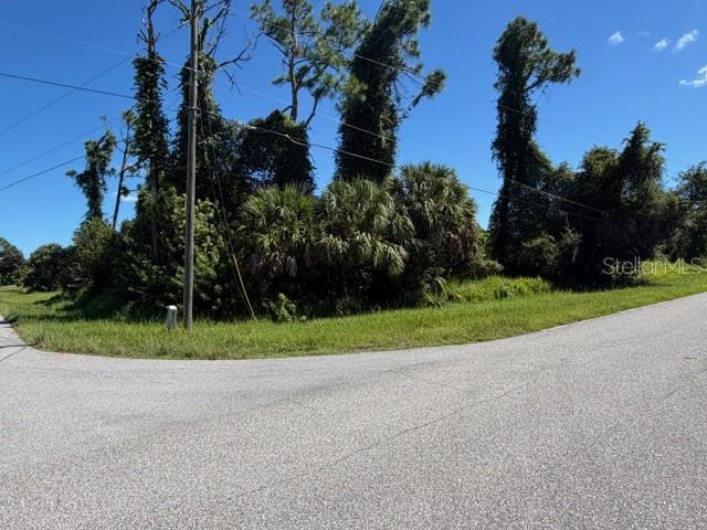 A paved road curves in front of a wooded lot with tall trees and vegetation — Lot 1 NORDENDALE BOULEVARD, NORTH PORT, FL