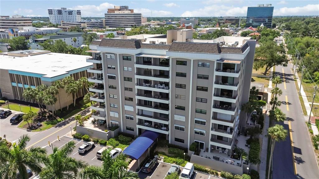 An aerial view shows a multi-story apartment building with balconies and an adjacent parking lot — 1400 BARCARROTA BOULEVARD UNIT 201, BRADENTON, FL