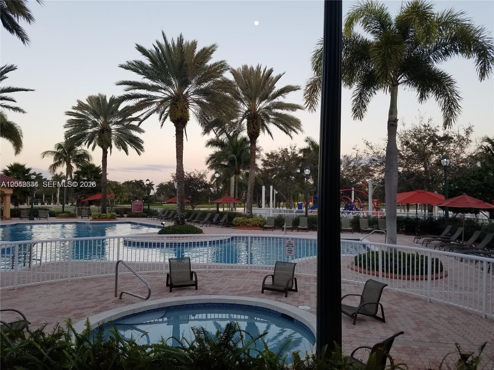 A swimming pool and hot tub area surrounded by palm trees and lounge chairs — 18741 SW 25th Ct # 18741, Miramar FL 33029, MIRAMAR, FL