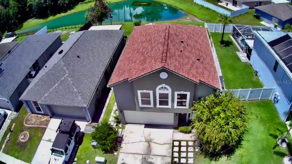 An aerial view shows a two-story house with a red shingled roof and driveway — 30341 PONGO WAY, WESLEY CHAPEL, FL