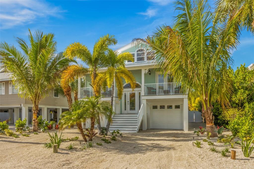 A light green two-story house with a white garage and palm trees in the yard — 510 MAGNOLIA AVENUE, ANNA MARIA, FL