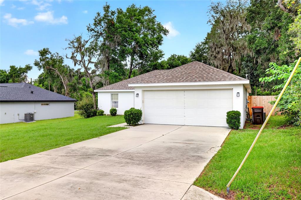 A white single-story house features a two-car garage and a concrete driveway — 45 LARCH RADIAL, OCALA, FL