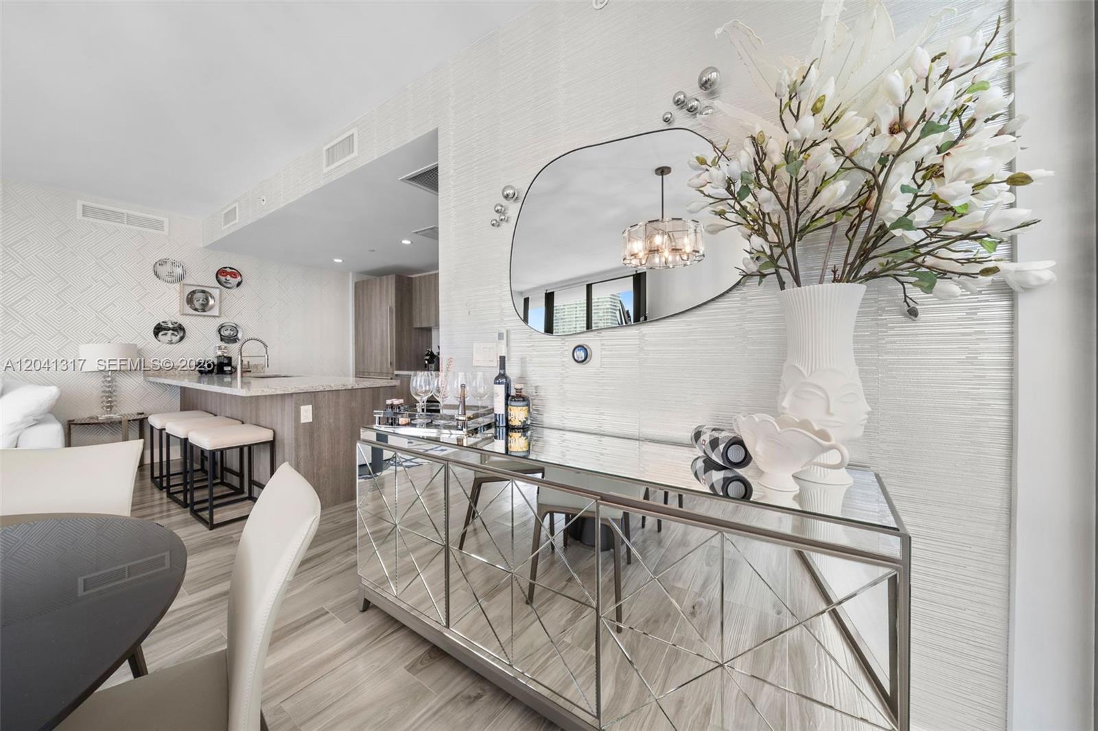 A dining area features a mirrored sideboard, a wall mirror, and a kitchen island — 801 S Miami Ave # 1604, Miami FL 33130, MIAMI, FL