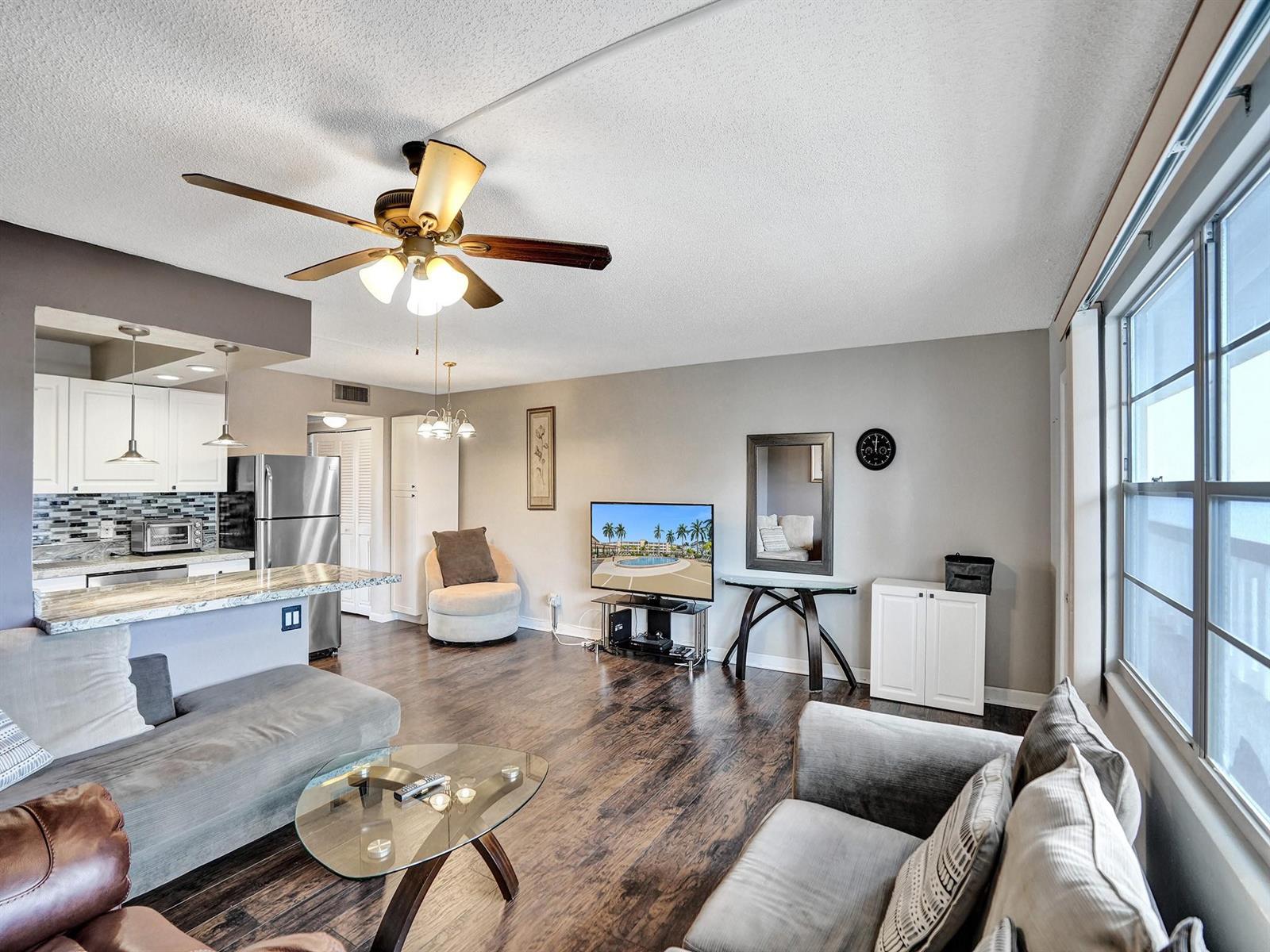 A living room with wood floors, a ceiling fan, and an open kitchen with island — 3014 Cornwall A, Boca Raton FL 33434, BOCA RATON, FL