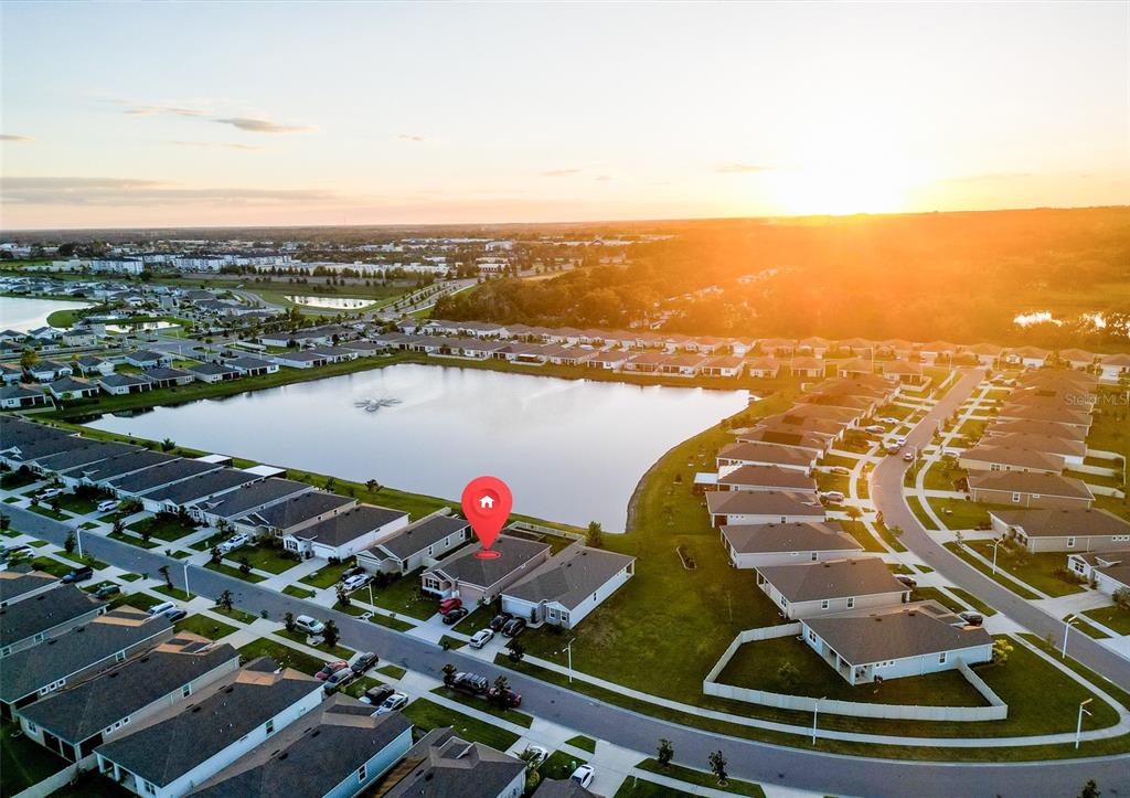 An aerial view of a backyard with a screened-in patio and a white vinyl fence — 8349 WHEAT STONE DRIVE, ZEPHYRHILLS, FL