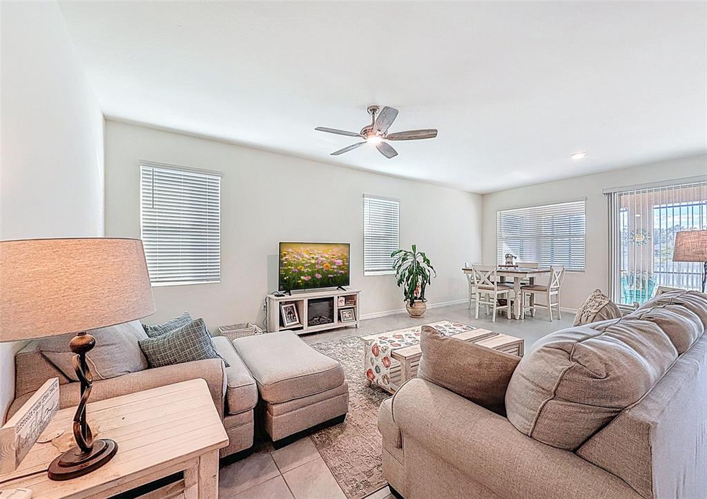 A hot tub sits inside a screened-in patio overlooking a lake at sunset — 8349 WHEAT STONE DRIVE, ZEPHYRHILLS, FL