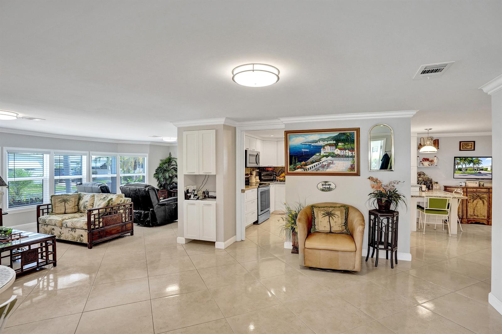 A living room with tile floors, a kitchen entryway, and a tan armchair — 120 NW 53rd Place, Pompano Beach FL 33064, POMPANO BEACH, FL
