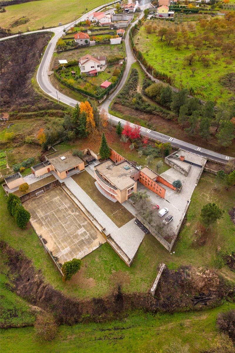 An aerial view shows a modern house with a tennis court and surrounding rural landscape — Numero 56 E Estrada Nacional 323,Moimenta da Beira, PT 3620, PT