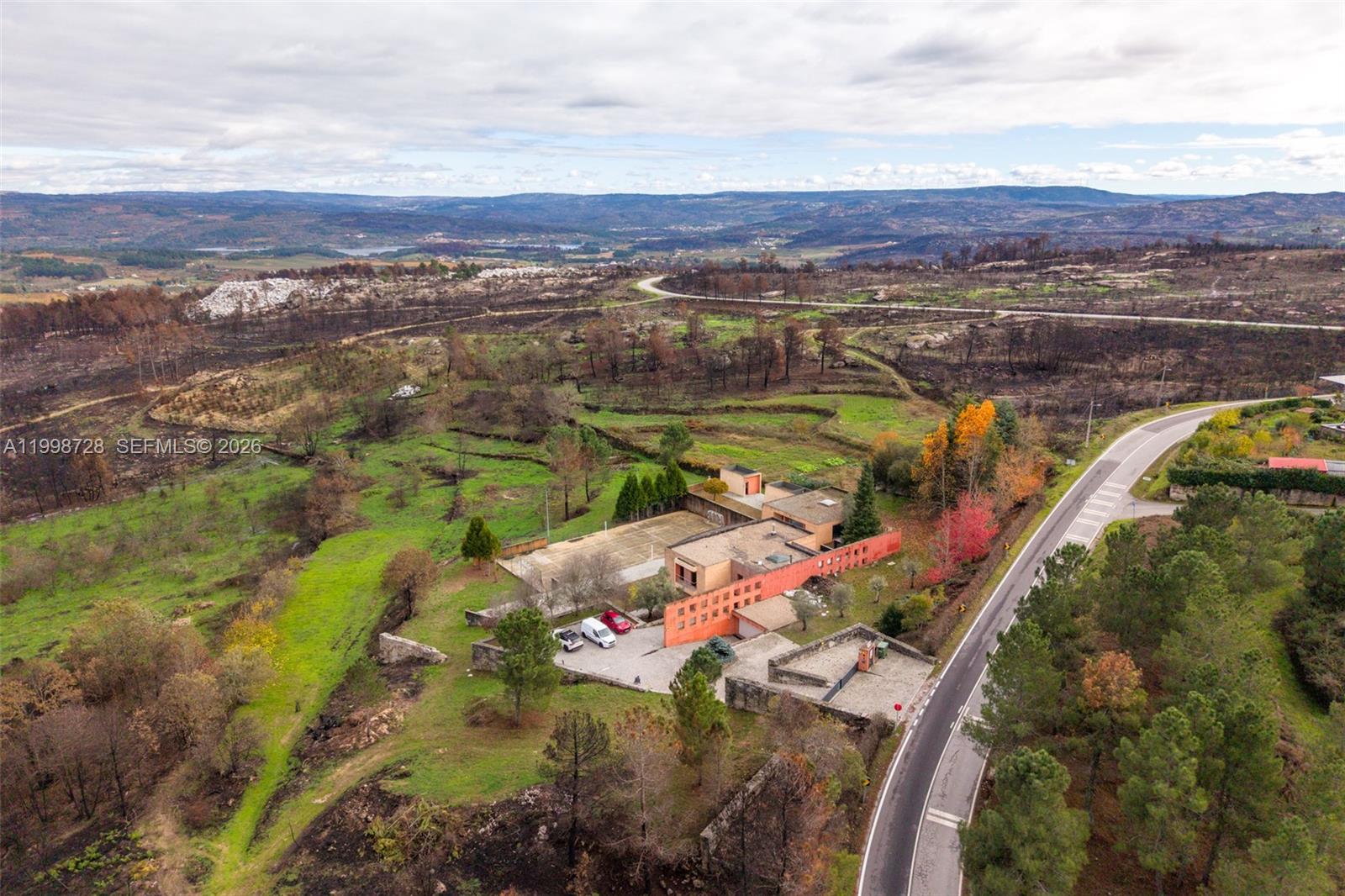 An aerial view shows a modern red building with a tennis court and parking area — Numero 56 E Estrada Nacional 323,Moimenta da Beira, PT 3620, PT