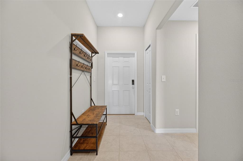 A single-story suburban house with a tan exterior, a two-car garage, and a front lawn — 11216 KELLY GREEN AVENUE, WIMAUMA, FL