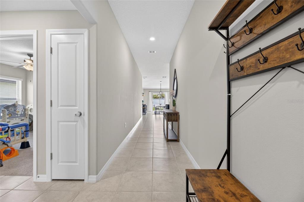 An entryway features a metal and wood hall tree, tile flooring, and a white door — 11216 KELLY GREEN AVENUE, WIMAUMA, FL