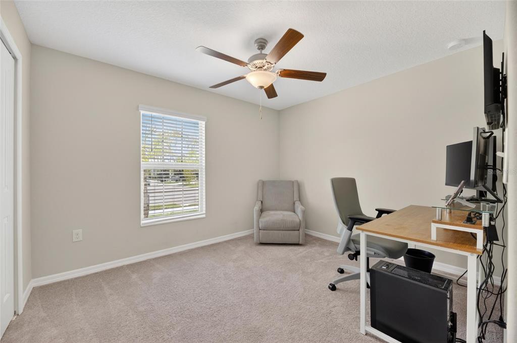 A hallway with light-colored walls and tile flooring leads to a bathroom and bedroom — 11216 KELLY GREEN AVENUE, WIMAUMA, FL