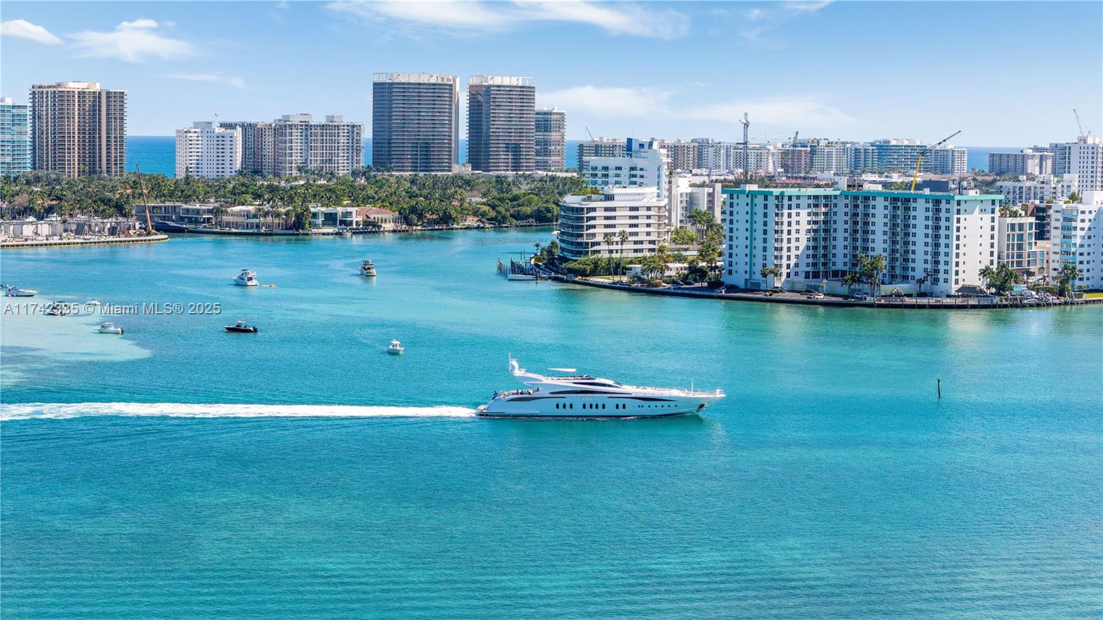 A large white yacht cruises through turquoise water in front of a coastal city skyline — 2700 NE 135th St # 32, North Miami FL 33181, NORTH MIAMI, FL