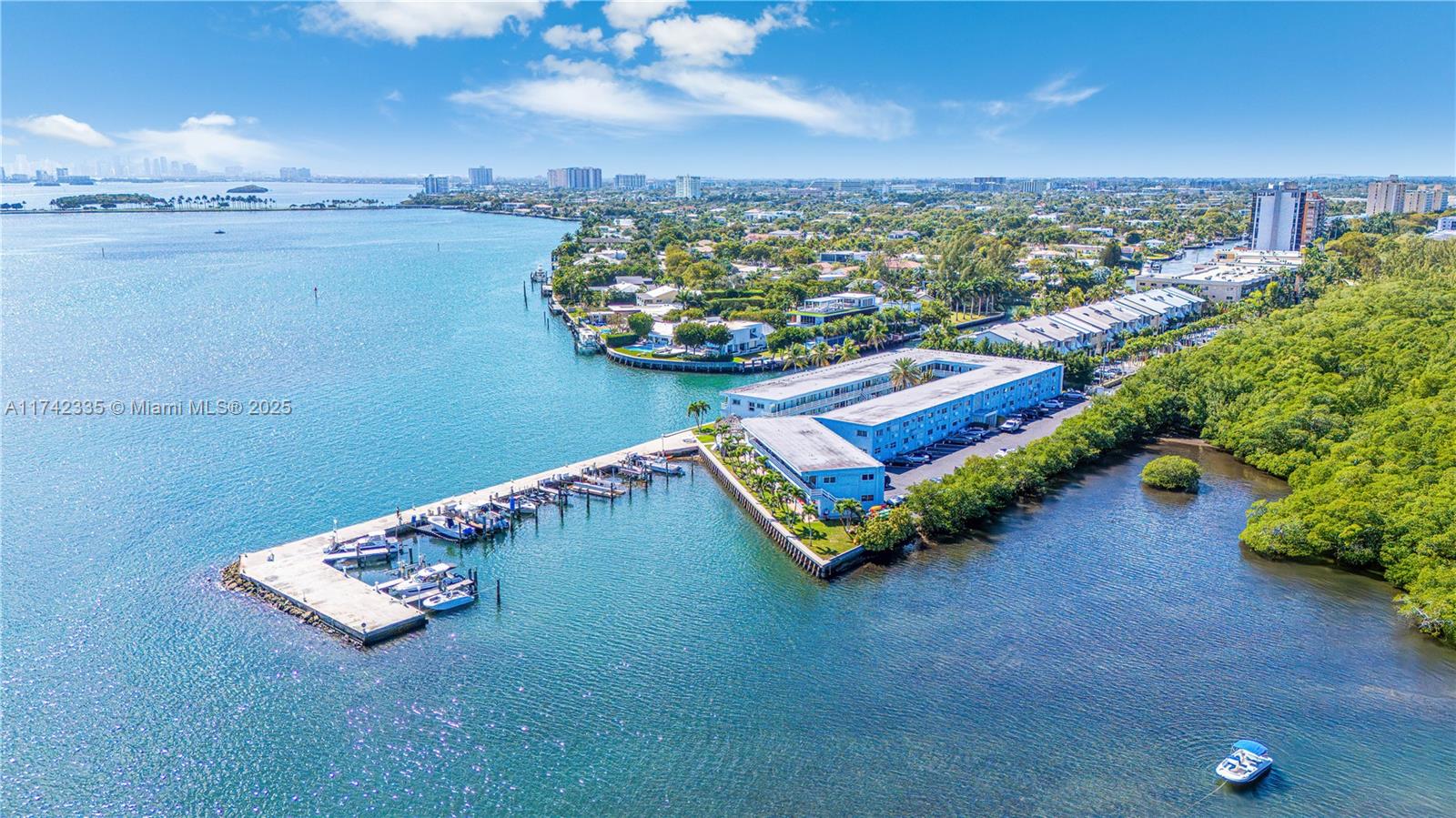 An aerial view shows a waterfront apartment complex with a private boat dock and marina — 2700 NE 135th St # 32, North Miami FL 33181, NORTH MIAMI, FL