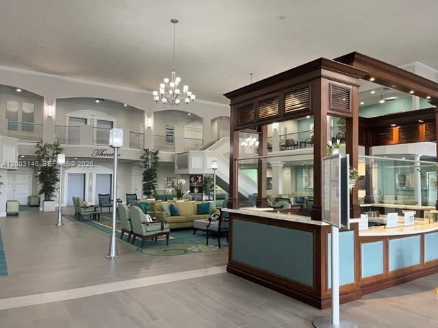 A spacious lobby features a large wooden reception desk, seating areas, and a chandelier — 150 Tuscany C # 150, Delray Beach FL 33446, DELRAY BEACH, FL