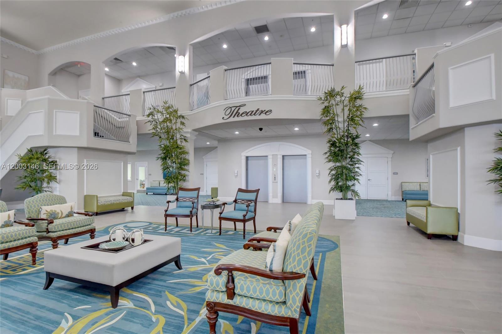 A spacious lobby features a patterned blue rug, seating areas, and a balcony labeled Theatre — 150 Tuscany C # 150, Delray Beach FL 33446, DELRAY BEACH, FL