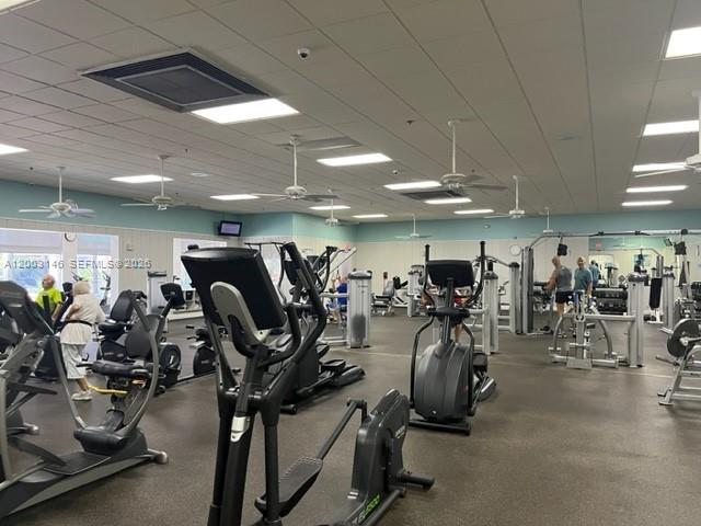 This gym features various exercise machines, recessed lighting, and ceiling fans in a spacious room — 150 Tuscany C # 150, Delray Beach FL 33446, DELRAY BEACH, FL