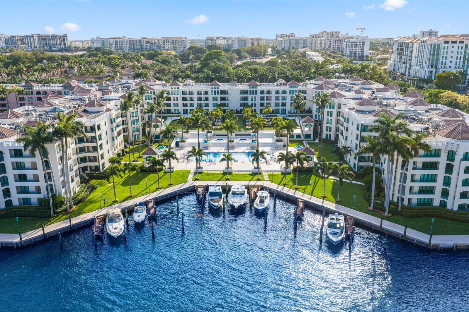 An aerial view of a multi-story apartment complex featuring a central pool and private boat slips — 100 SE 5th Avenue # 106, Boca Raton FL 33432, BOCA RATON, FL