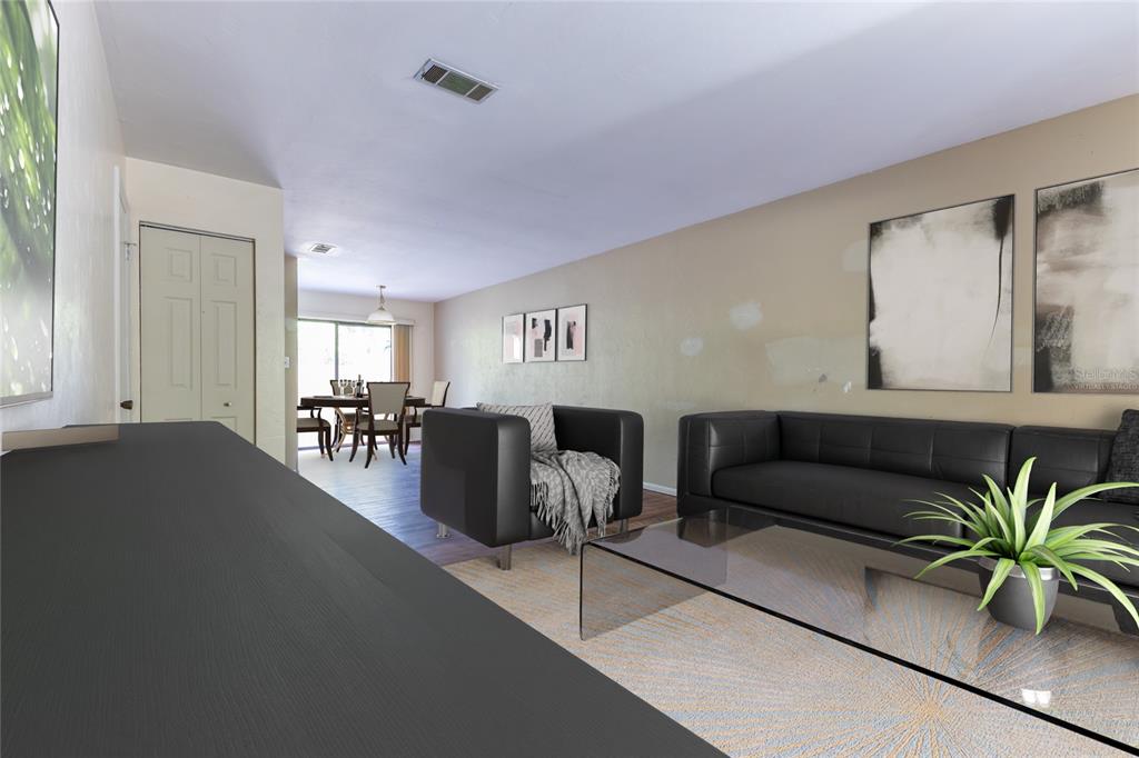 A living room with black furniture, a glass coffee table, and an adjacent dining area — 4314 NW 41ST LANE UNIT 73, GAINESVILLE, FL