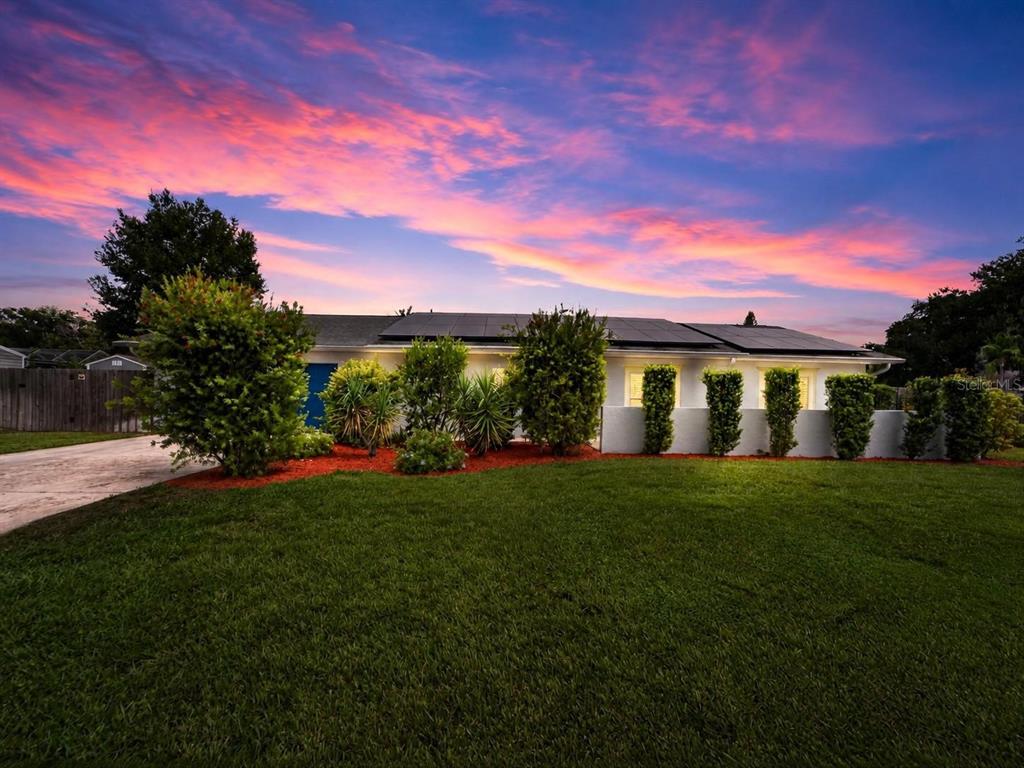 A single-story house with solar panels on the roof and a landscaped front yard — 1120 LAKEMONT DRIVE, VALRICO, FL