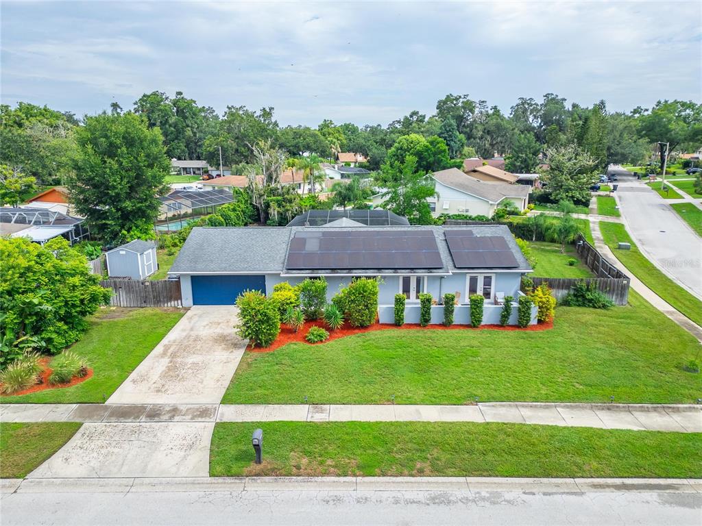 An aerial view of a single-story house with solar panels and a front lawn — 1120 LAKEMONT DRIVE, VALRICO, FL