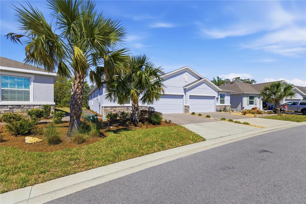A light-colored duplex home with two garage doors and palm trees in the front yard — 5369 NW 48TH PLACE, OCALA, FL
