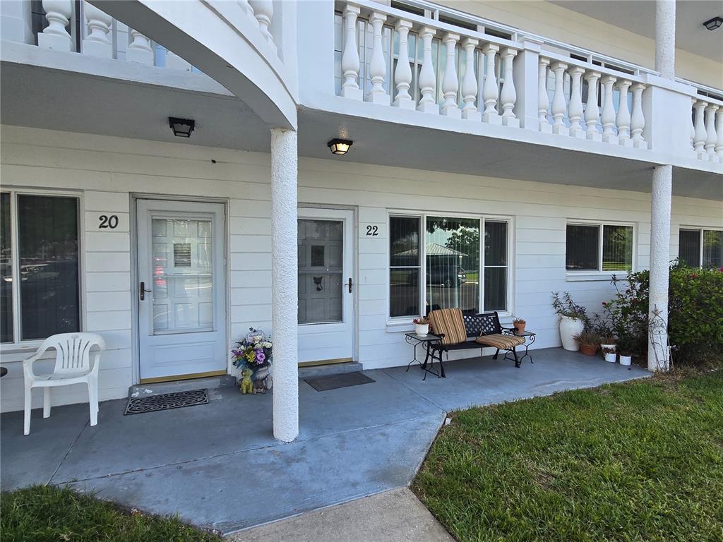 The exterior of a two-story residential building features two numbered unit entrances and a patio — 2428 COLUMBIA DRIVE UNIT 22, CLEARWATER, FL