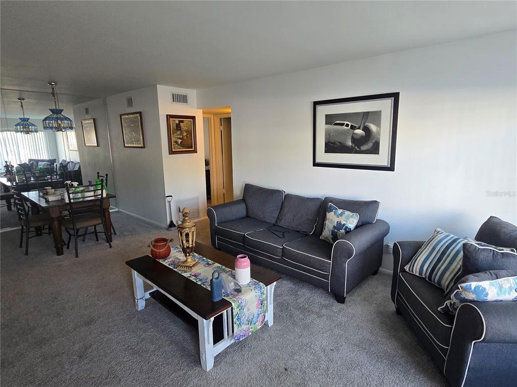A living room with gray furniture, a coffee table, and an adjacent dining area — 2428 COLUMBIA DRIVE UNIT 22, CLEARWATER, FL