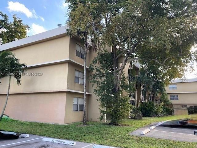 A three-story tan apartment building is surrounded by trees and a parking lot — 4205 N UNIVERSITY DR # 309, Sunrise FL 33351, SUNRISE, FL