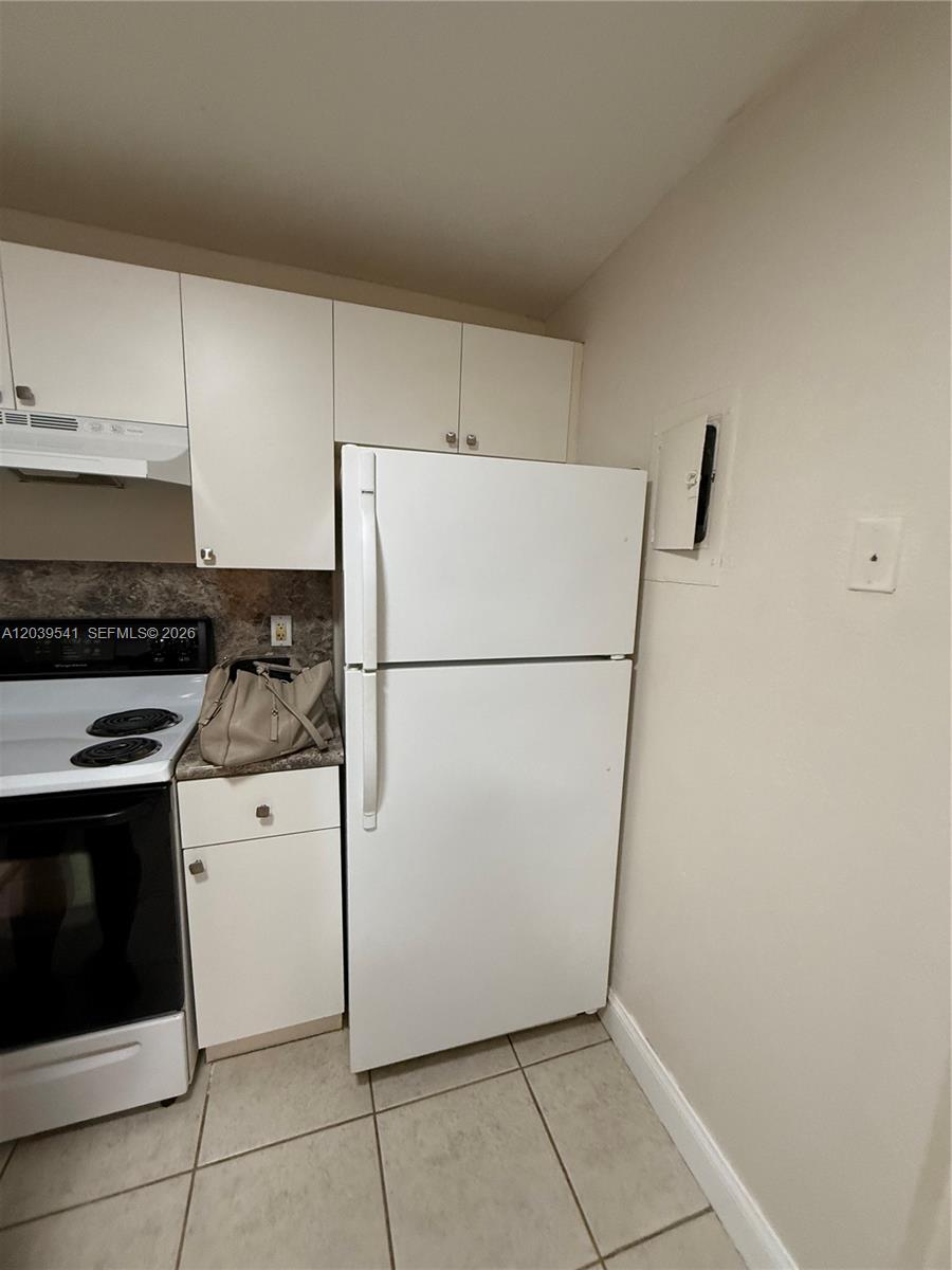 A white refrigerator stands next to a white stove in a small kitchen — 4205 N UNIVERSITY DR # 309, Sunrise FL 33351, SUNRISE, FL