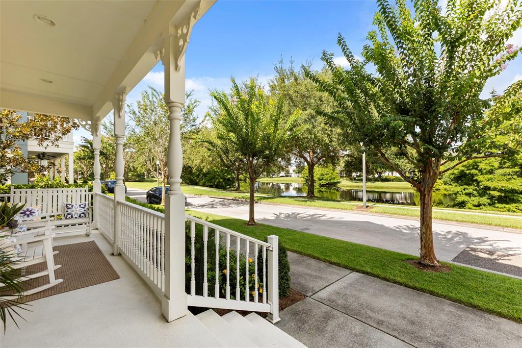 A paved street runs alongside a pond lined with green trees and grassy banks — 5492 PENWAY DRIVE, ORLANDO, FL
