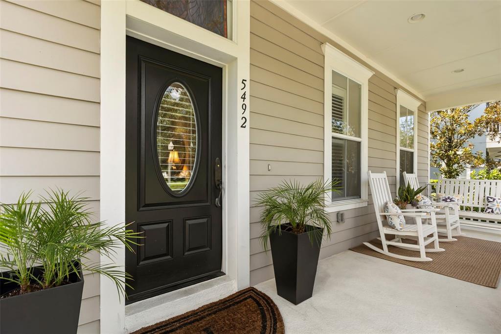 A two-story house with light gray siding, a front porch, and a second-floor balcony — 5492 PENWAY DRIVE, ORLANDO, FL