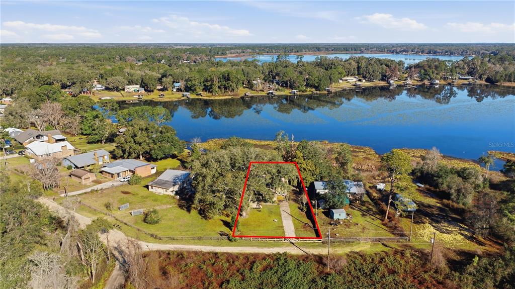 An aerial view shows a rectangular property lot outlined in red near a large lake — 872 LAKE SHORE TERRACE, INTERLACHEN, FL