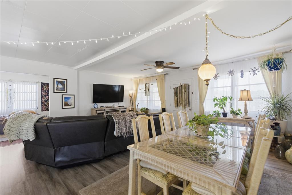 A living and dining area features white walls, wood-look flooring, and a glass-topped table — 872 LAKE SHORE TERRACE, INTERLACHEN, FL