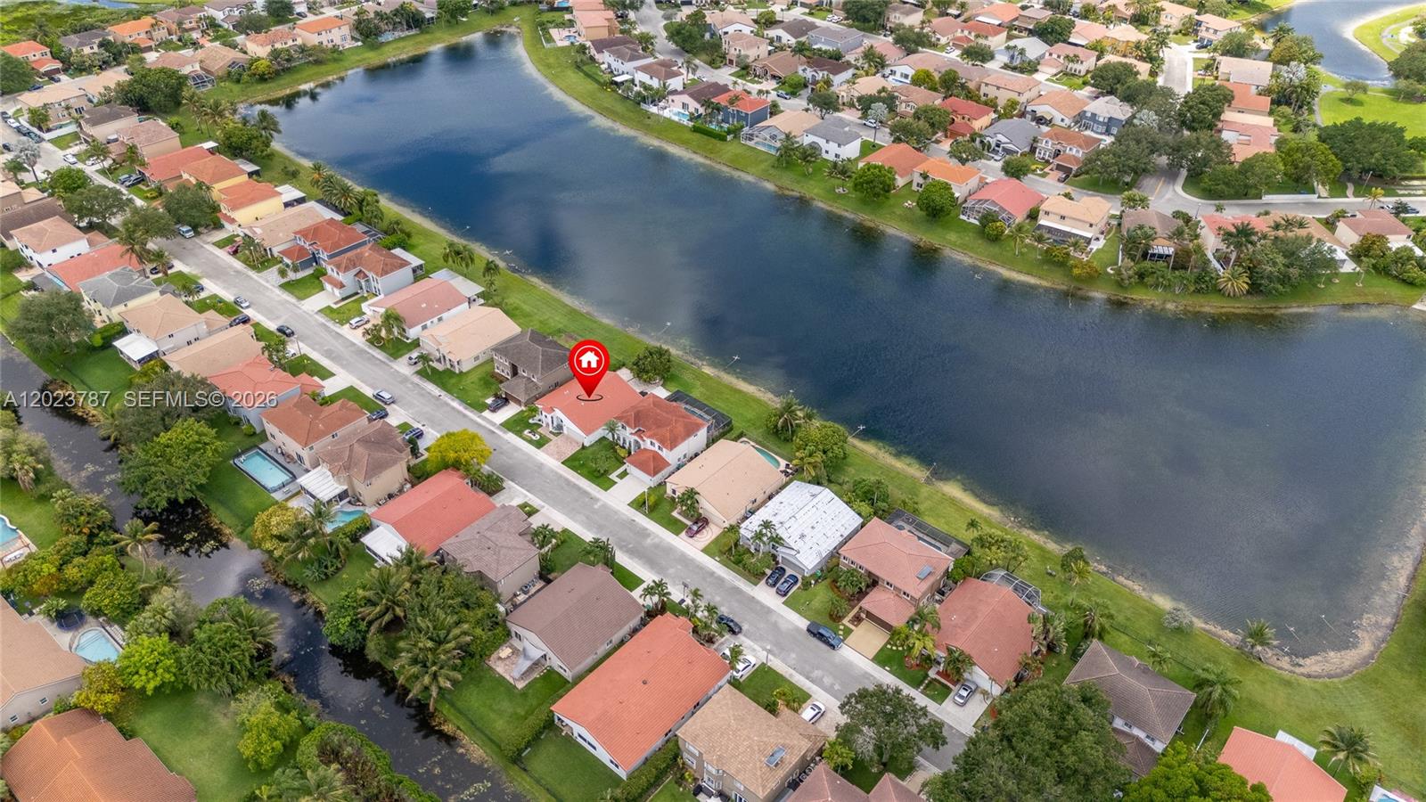 An aerial view shows a residential neighborhood with houses situated along a large lake — 1601 SW 106th Ter, Davie FL 33324, DAVIE, FL
