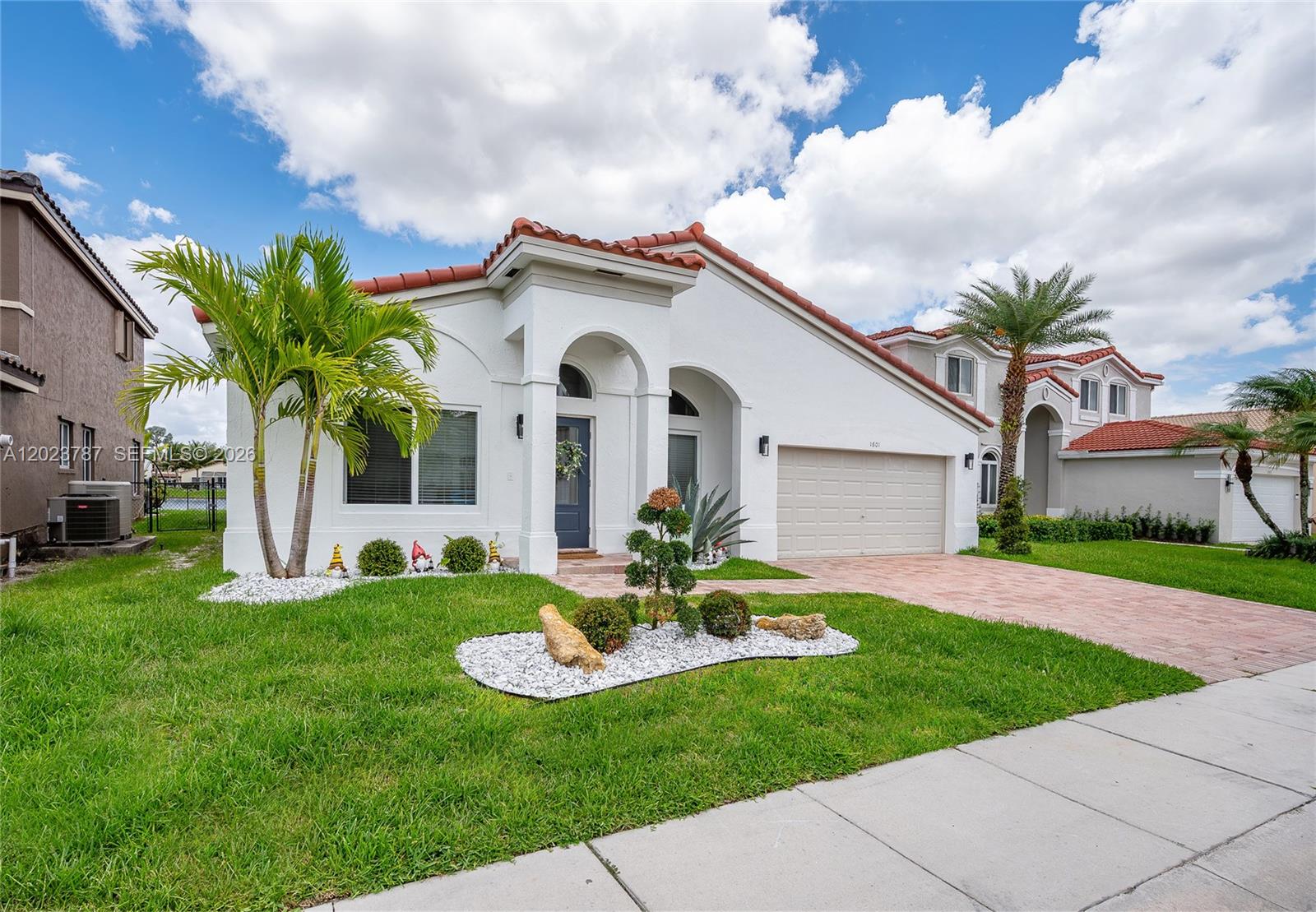 A white single-story house with a red tile roof, a garage, and a landscaped yard — 1601 SW 106th Ter, Davie FL 33324, DAVIE, FL