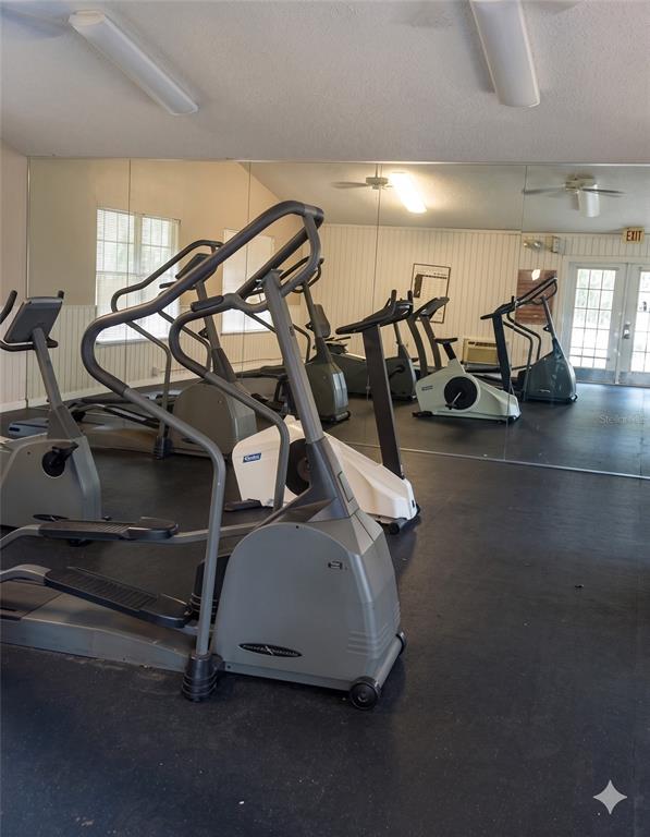 A gym room features several elliptical machines and stationary bikes on a black floor — 625 DORY LANE UNIT 303, ALTAMONTE SPRINGS, FL