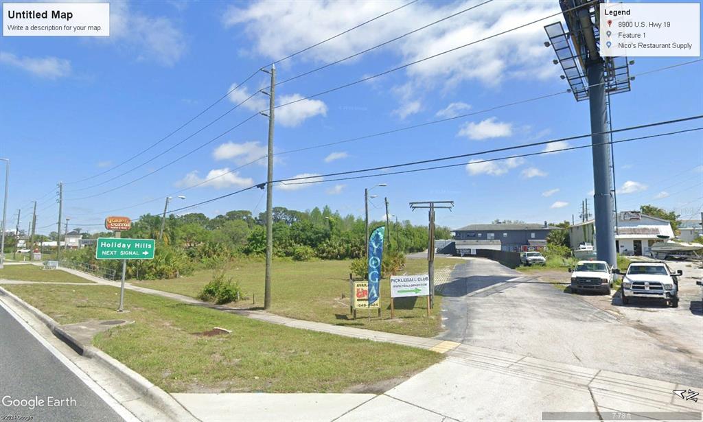 This is a street-level view of a vacant lot with a billboard and signage — 8900 US 19 HIGHWAY, PORT RICHEY, FL