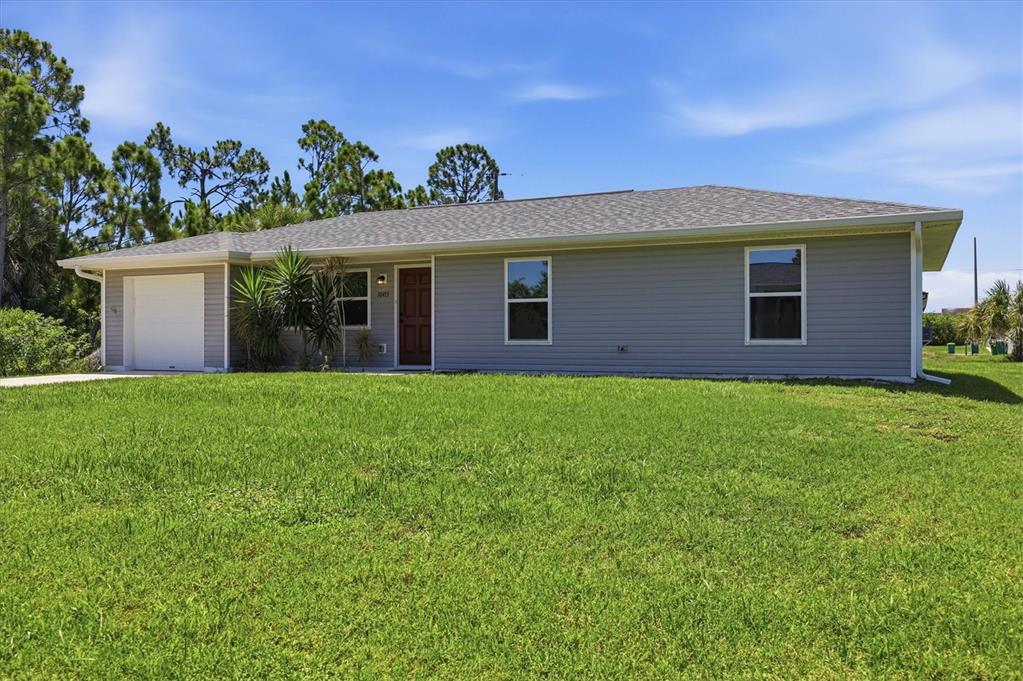 A single-story gray house with a white garage door and a large front lawn — 10453 REIMS AVENUE, ENGLEWOOD, FL