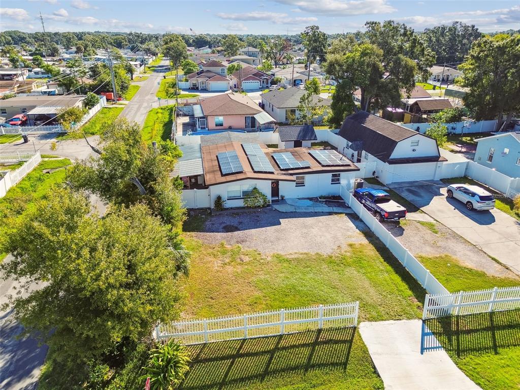 An aerial view shows a single-story house with solar panels and a detached garage — 5825 N THATCHER AVENUE, TAMPA, FL