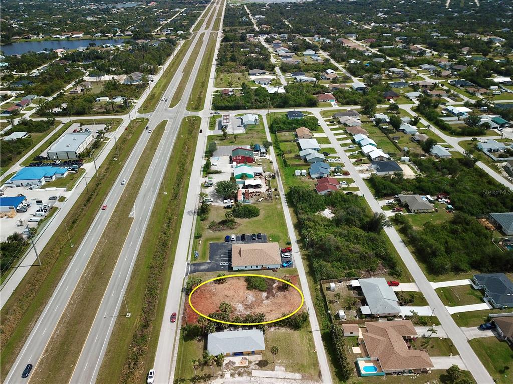 An aerial view shows a vacant, cleared lot highlighted by a yellow oval near a highway — 4303 & 4307 S ACCESS ROAD, ENGLEWOOD, FL