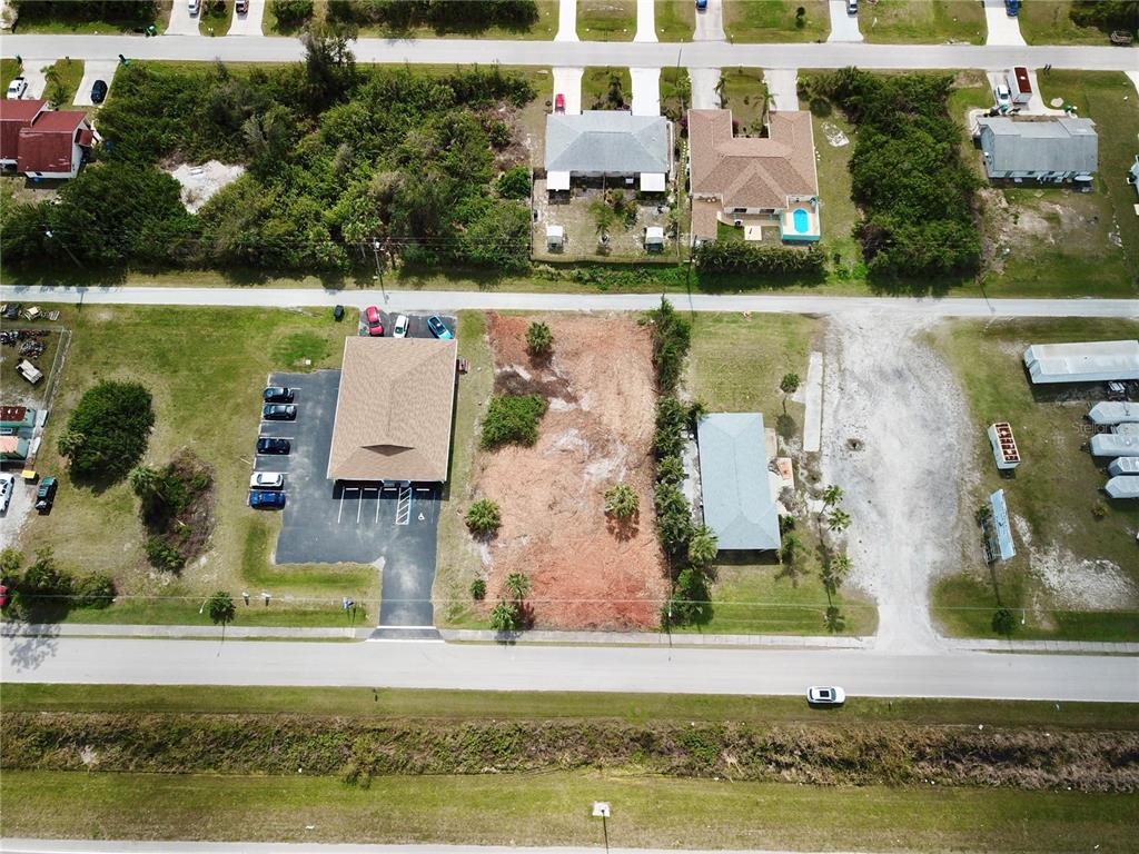 An aerial view shows a vacant lot situated between two commercial buildings and a road — 4303 & 4307 S ACCESS ROAD, ENGLEWOOD, FL