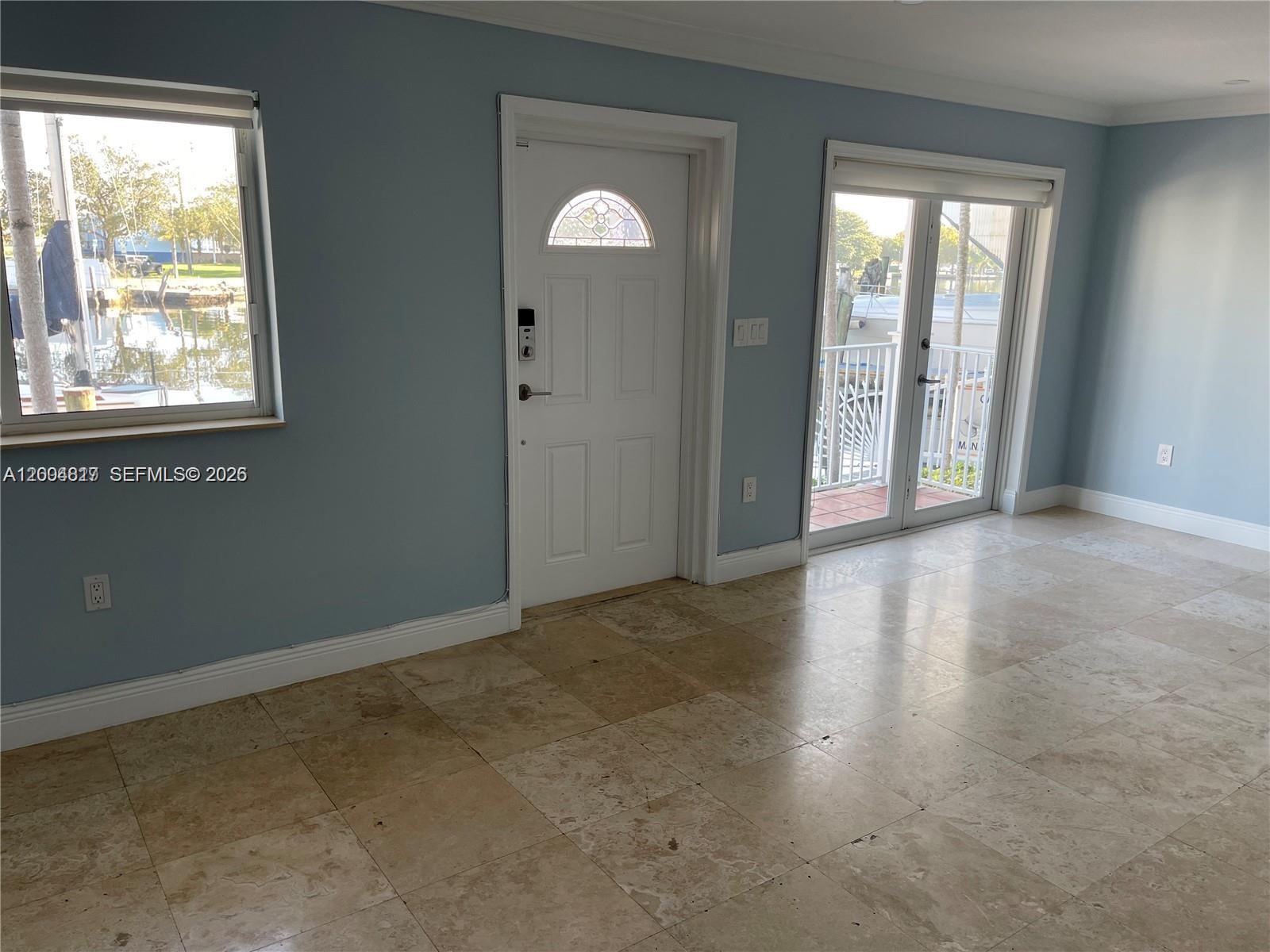 A room with light blue walls, tile flooring, a white door, and a glass sliding door — 2415 NW 16th St Rd # 102, Miami FL 33125, MIAMI, FL