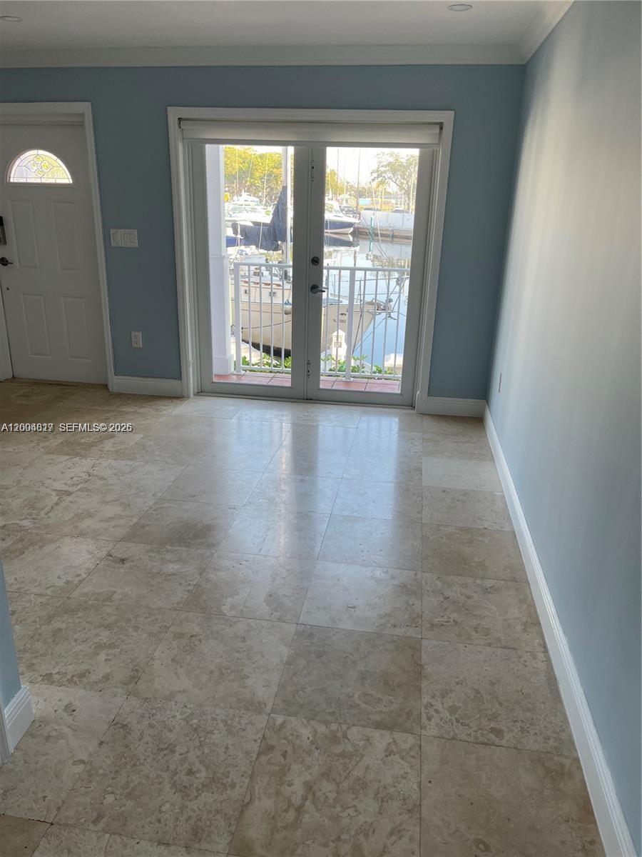 A room with light blue walls, tile flooring, and French doors opening to a marina view — 2415 NW 16th St Rd # 102, Miami FL 33125, MIAMI, FL