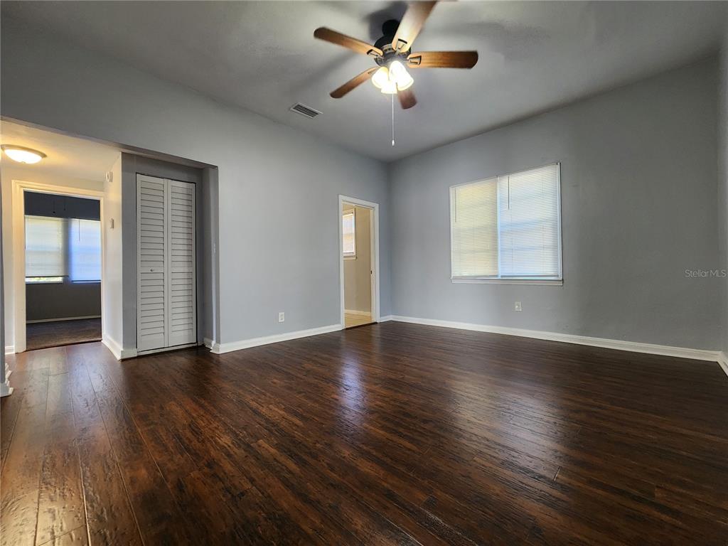 A room with dark wood flooring, light gray walls, a ceiling fan, and two doorways — 1238 CLEVELAND STREET, JACKSONVILLE, FL