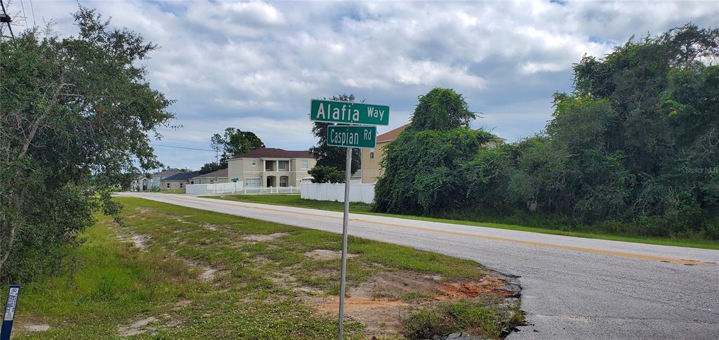 A street sign at the intersection of Alafia Way and Caspian Road near residential homes — 1227 ALAFIA WAY, KISSIMMEE, FL